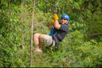 Man Zooming Across A Rainforest Field On Blue River Zipline
 - Costa Rica